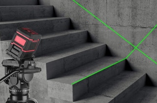 a leveling laser with a green beam on a wall over stairs