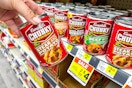 hand holding up a can of campbell's chunky soup at dollar general