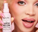 a person holding a pink bottle of makeup spray