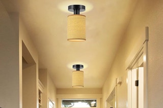 Two ceiling lights with yellow cloth shades illuminate a hallway.
