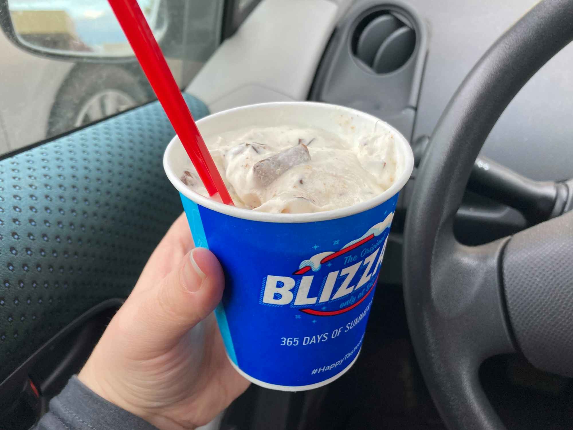 Someone holding a Dairy Queen Puppy Chow Blizzard