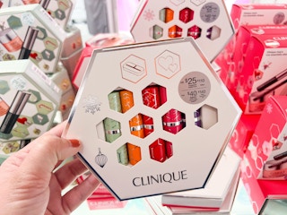 someone holding a clinique 5-piece gift set