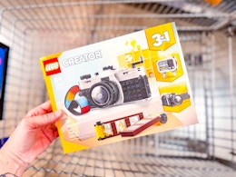hand holding lego retro camera over walmart cart
