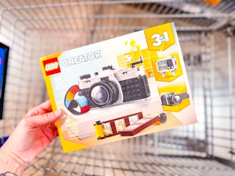 hand holding lego retro camera over walmart cart
