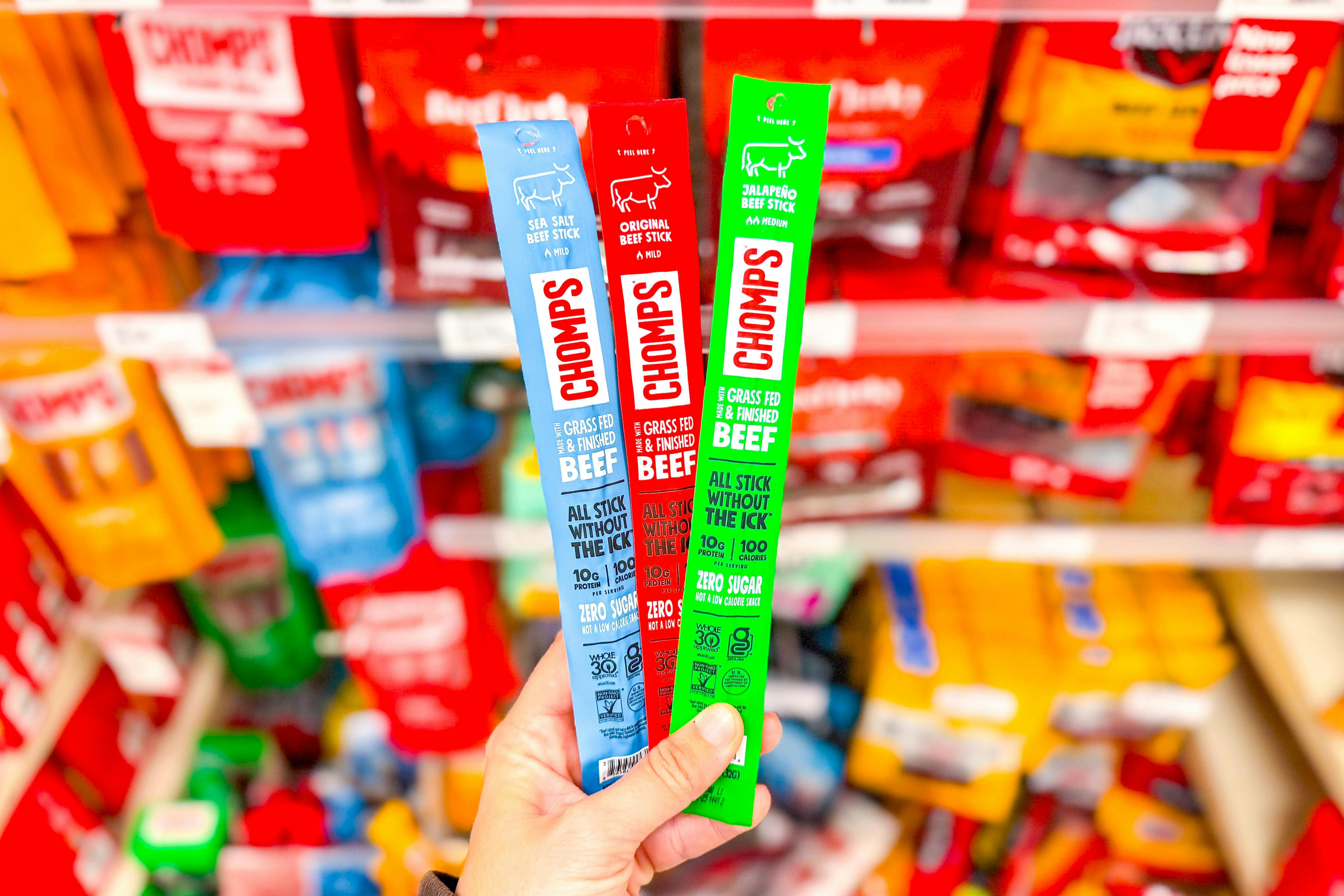 hand holding 3 chomps meat sticks at target