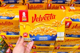 hand holding a pack of velveeta shells and cheese