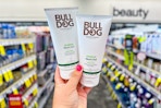 person holding 2 bulldog shave gels in an aisle