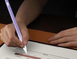 a person writing with a purple iPad pencil