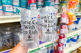 hand holding two packs of dollar tree plastic cups with sip lids
