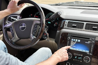 A man pushes a button on a sirius car satellite radio