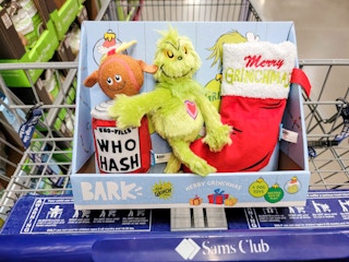a 4-pack of bark grinch dog toys in a cart