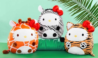 three squishmallows hello kitty plush toys on a green tropical set