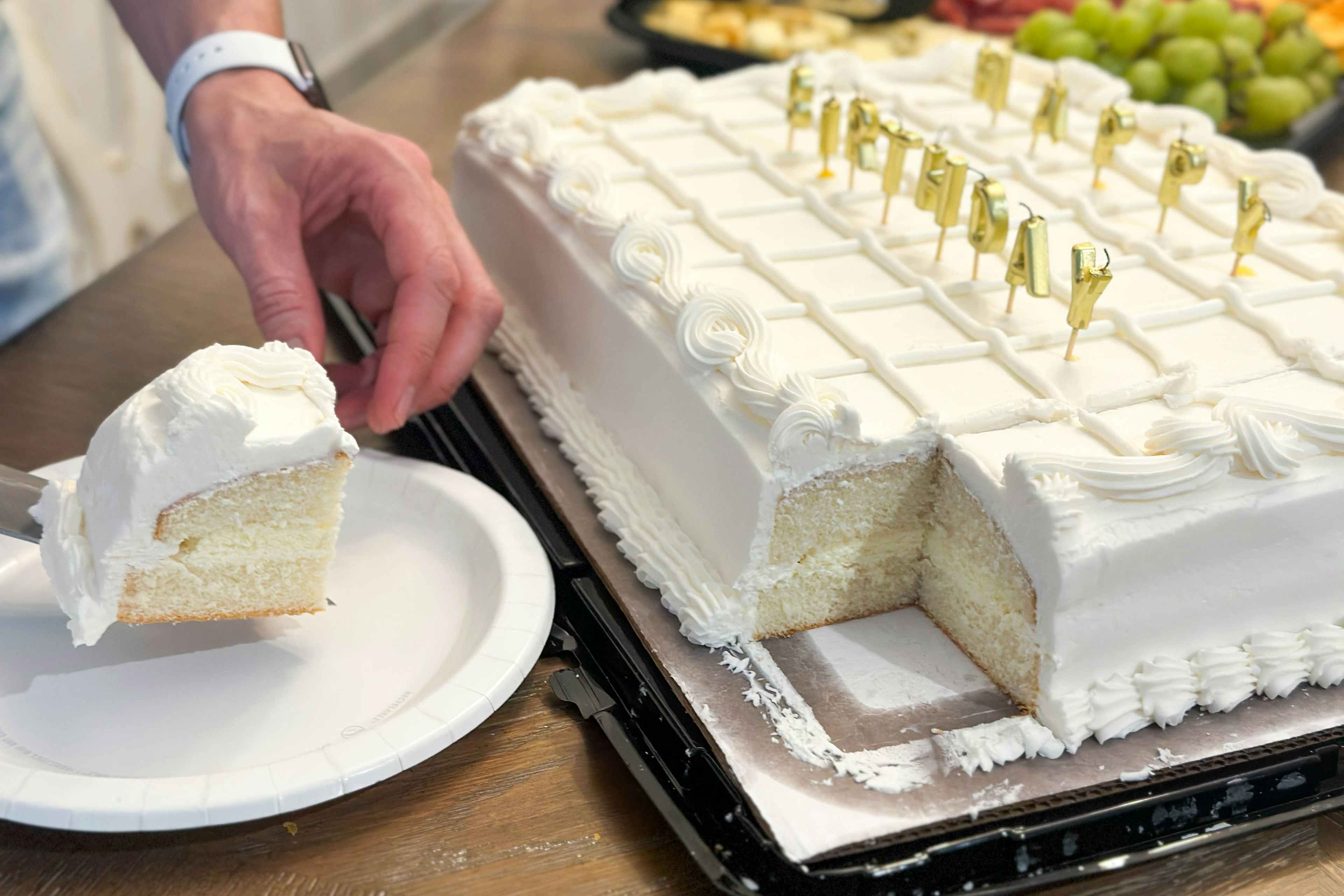 someone cutting a piece out of a costco sheet cake