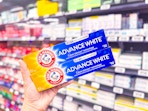 2 Arm & Hammer extreme whitening toothpaste boxes held up in Walmart store