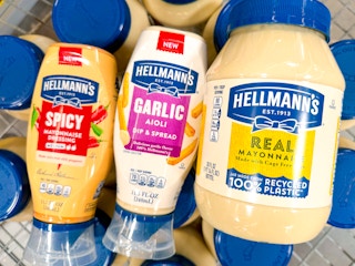 Hellmann's Spicy mayo, Garlic Aioli, and container of regular mayonnaise on top of other condiment bottles