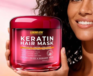 a person holding a red hair mask jar