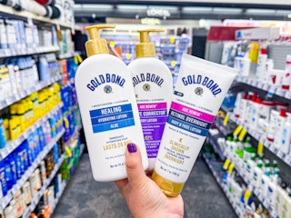 hand holding three gold bond lotions