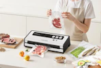 woman using fresko vacuum sealer on kitchen island