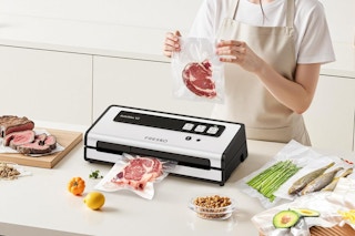 woman using fresko vacuum sealer on kitchen island