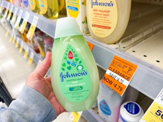 person holding a bottle of johnsons baby bath by a $4.79 clearance sign