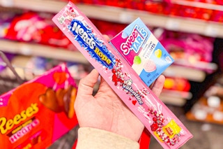 person holding nerds rope and sweetarts over reese's hearts