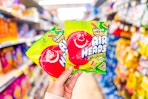 hand holding 2 bags of air heads candy