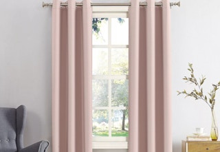 A pink curtain panel hangs from a rod in a room