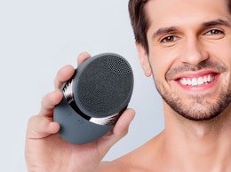 a person holding an electric facial brush