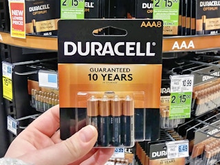 a person holding duracell batteries in a rite aid