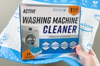 a blue and white box and an Amazon bubble mailer in a hand 