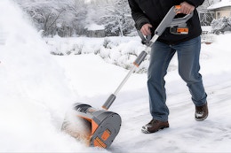 Man using the Keenstone 12" Snow Shovel to shovel driveway snow.