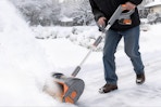 Man using the Keenstone 12" Snow Shovel to shovel driveway snow.