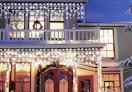 icicle lights on the front of a house with Christmas decorations