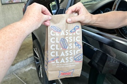 a person handing a sonic bag to a person to a person sitting in a car