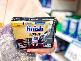 hand holding finish ultimate dishwasher tabs tubs