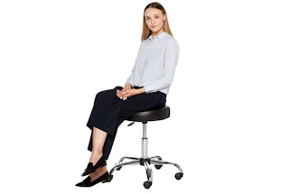 A woman sitting on a black bar stool.