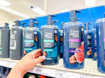 hand grabbing a dove men+care plant based body wash off a target shelf