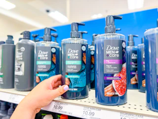 hand grabbing a dove men+care plant based body wash off a target shelf