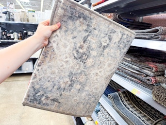 In store photo of the Mainstays Persian accent rug (held up)