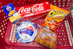 kraft mac & cheese, dixie paper plates, coca-cola, cheetos, and ball park hot dog buns in a cart