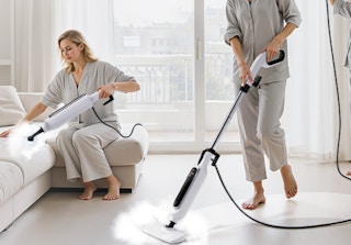people cleaning a floor and couch with steam mops 
