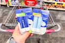person holding 2 2-packs of nivea lip balm over a cart