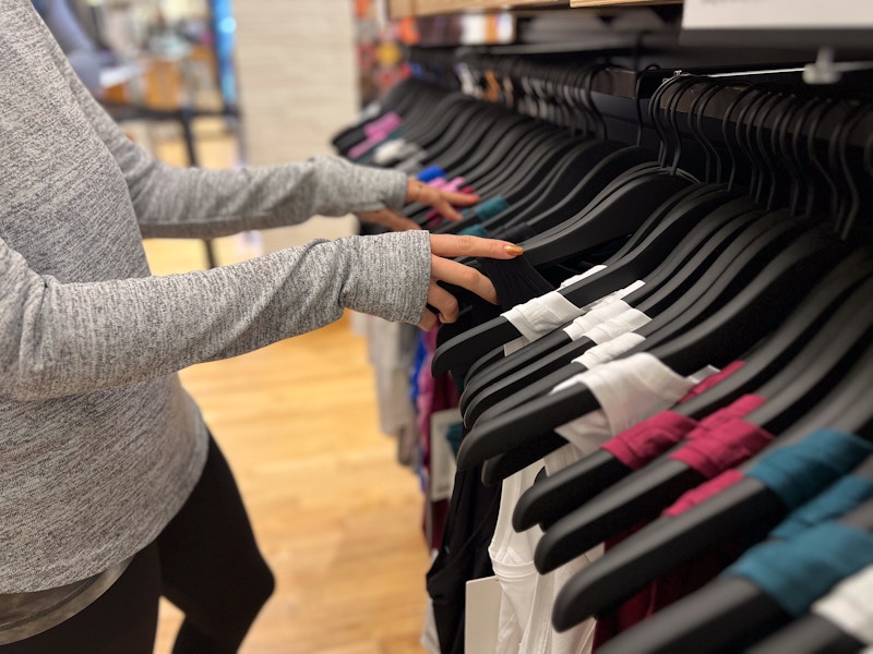 model shifting through clothing racks