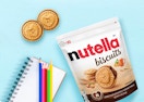 a bag of Nutella biscuits next to two biscuits and a notebook