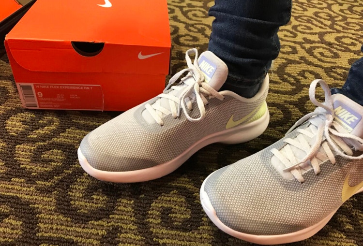 Person wearing Nike shoes next to orange Nike box