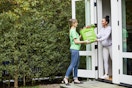 instacart delivery person handing bag to person in house