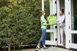 instacart delivery person handing bag to person in house