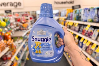 person holding a large bottle of snuggle fabric softener in an aisle