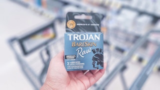 hand holding a package of condoms