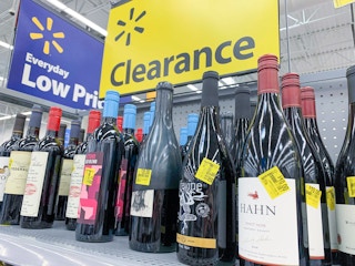 bottles of wine on walmart shelf with clearance sign in background